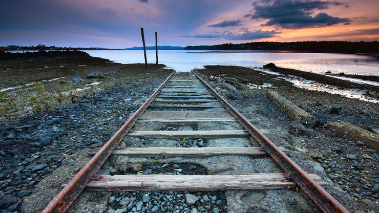 Page_rusty_train_tracks_leading_down_into_a_lake.1920x1080.8a7a5bae